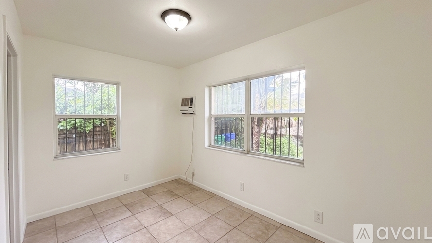 A room with two windows and a tiled floor.