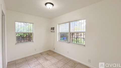 A room with two windows and a tiled floor.