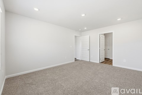 A spacious room with carpeted floor and white walls.