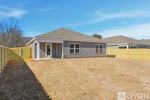 A house with a grey roof and a yellow fence is available for sale.