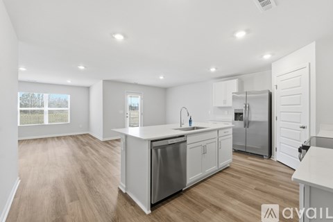 A modern kitchen with white cabinets and stainless steel appliances.