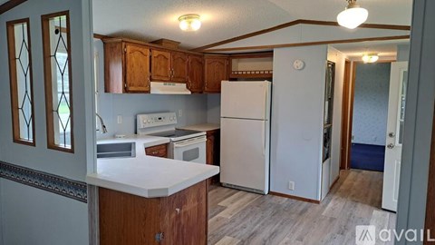 A kitchen with wooden cabinets and a white fridge.
