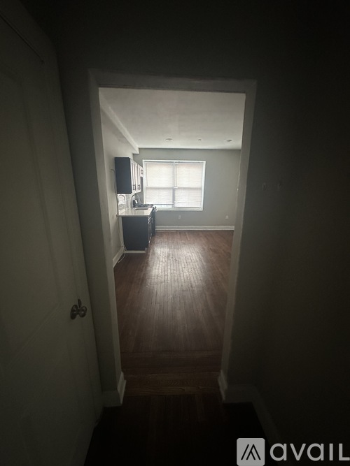 A dark hallway leading to a kitchen.