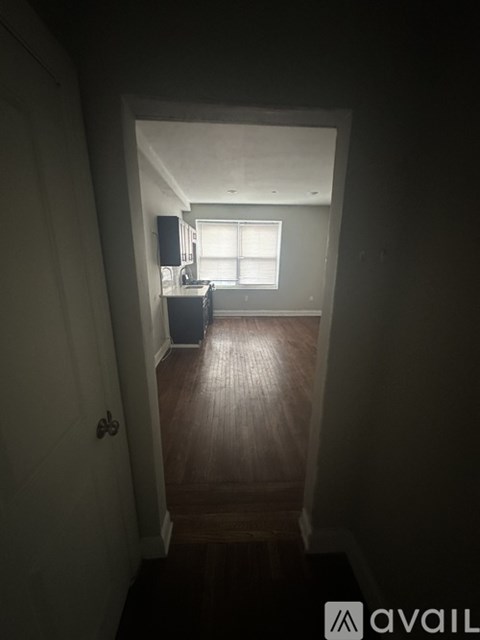 A dark hallway leading to a kitchen.