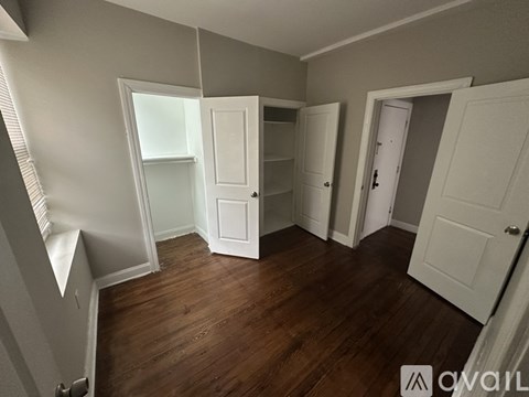 A room with white doors and a wooden floor.