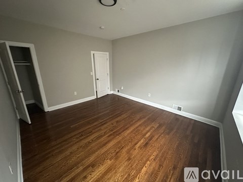 A room with wooden flooring and a white door.