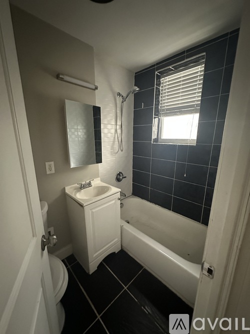 A small white bathroom with a sink, toilet and bathtub.