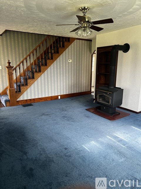 A living room with a staircase and a fireplace.