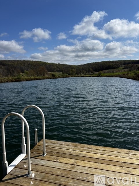 A wooden dock with metal railings over a calm body of water.