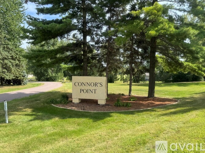 A sign that says Connor's Point is surrounded by trees.