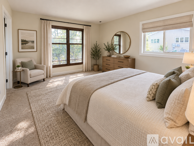 A well-lit bedroom with a large bed and a view of the outdoors through the window.
