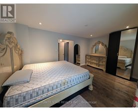 A bedroom with a large bed and a dresser with a mirror.
