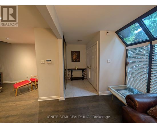 A living room with a couch, a chair, and a painting on the wall.