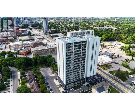 A tall building stands in the middle of a city with roads and other buildings in the background.