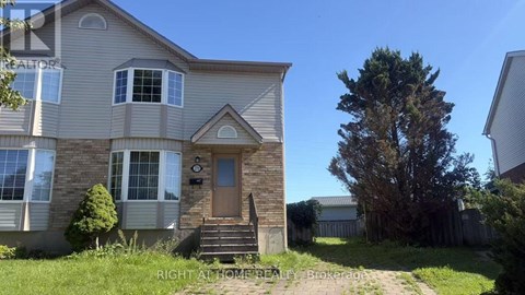 A house with a brown door and a small tree in front.