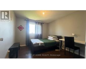 A bedroom with a bed, desk, and chair is for rent.