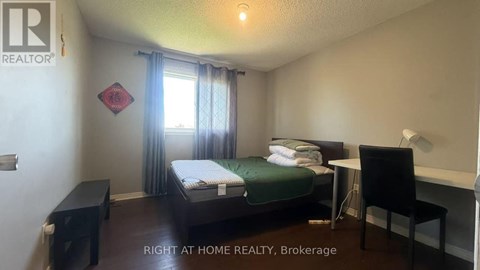 A bedroom with a bed, desk, and chair is for rent.