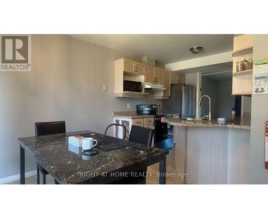 A kitchen with a table and chairs in front of it.