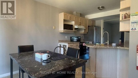 A kitchen with a table and chairs in front of it.
