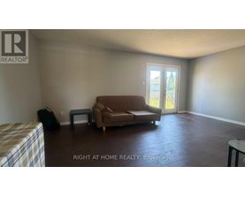 A living room with a couch, chair, and television.