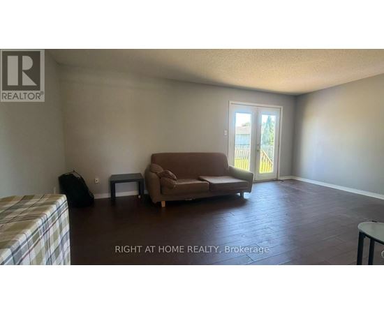 A living room with a couch, chair, and television.