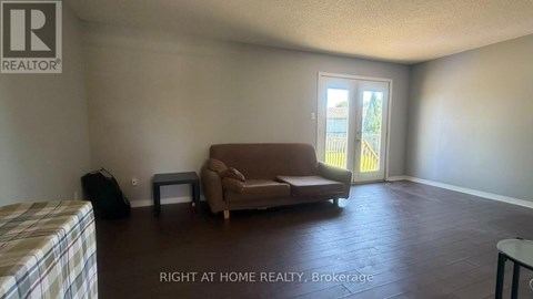A living room with a couch, chair, and television.