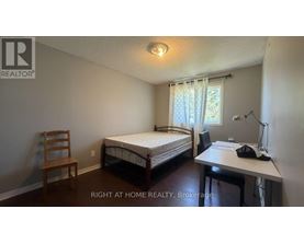 A bedroom with a bed, desk, and chair.