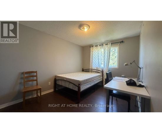 A bedroom with a bed, desk, and chair.