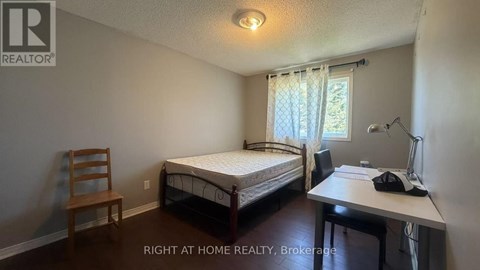 A bedroom with a bed, desk, and chair.