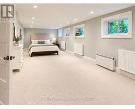 A bedroom with a large bed and a window with a view of trees.