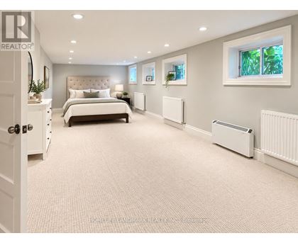 A bedroom with a large bed and a window with a view of trees.
