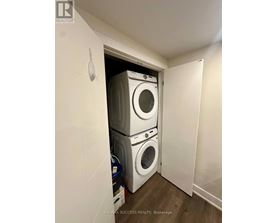 A laundry room with a stack of washing machines.