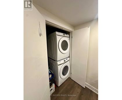 A laundry room with a stack of washing machines.