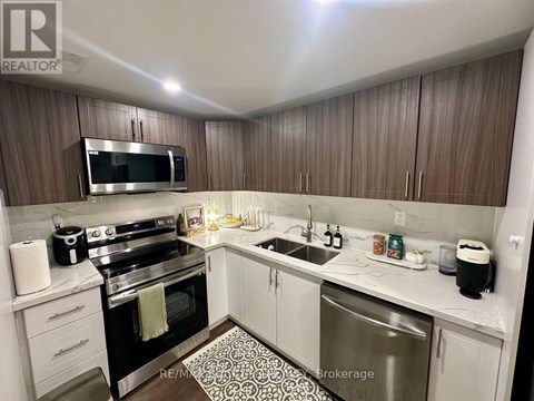 A kitchen with a stove top oven, microwave, and sink.
