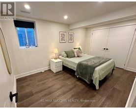 A bedroom with a bed, nightstand, and lamp.