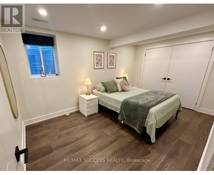 A bedroom with a bed, nightstand, and lamp.