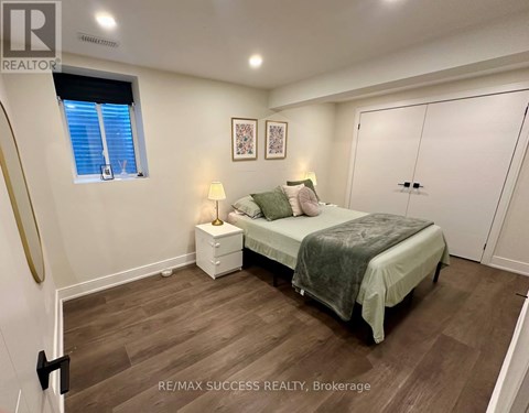 A bedroom with a bed, nightstand, and lamp.