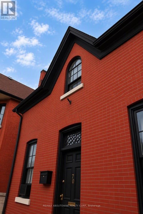 A red brick building with a black door and windows.