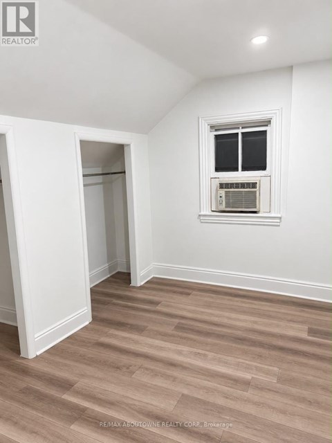 A room with a window and a wall-mounted air conditioner unit.
