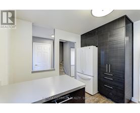 A modern kitchen with a white countertop and black cabinets.