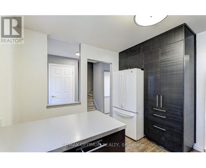 A modern kitchen with a white countertop and black cabinets.
