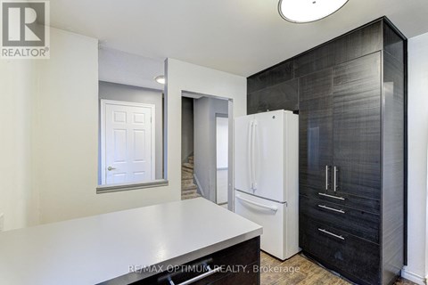 A modern kitchen with a white countertop and black cabinets.