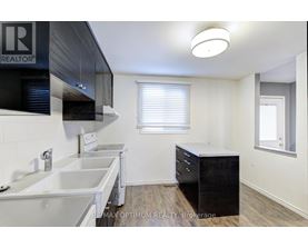 A kitchen with white countertops and a black cabinet.