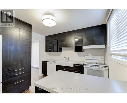 A modern kitchen with black cabinets and white appliances.