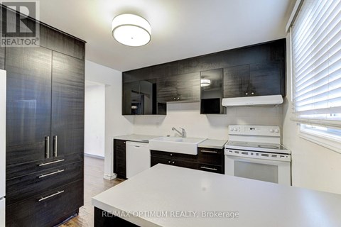 A modern kitchen with black cabinets and white appliances.