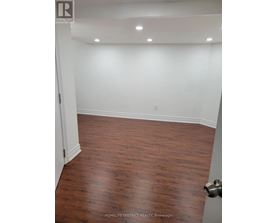 A room with wooden flooring and white walls.