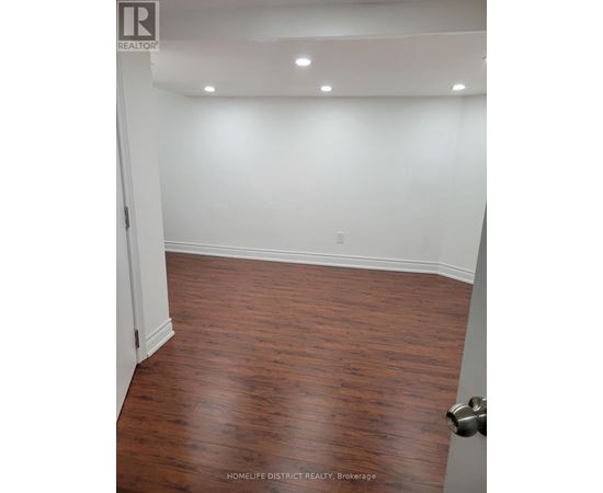 A room with wooden flooring and white walls.
