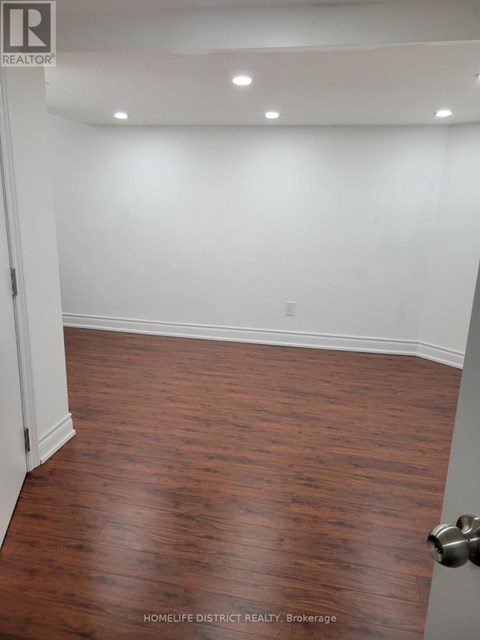 A room with wooden flooring and white walls.