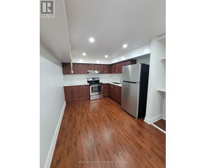 A kitchen with wooden floors and stainless steel appliances.
