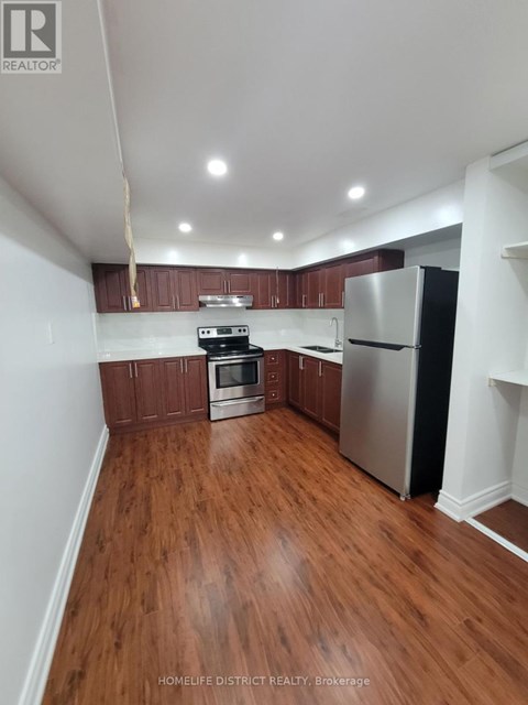 A kitchen with wooden floors and stainless steel appliances.